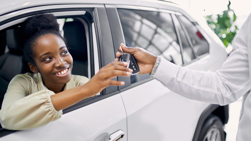 portrait good looking afro lady getting keys by car