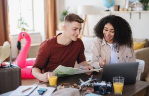 Young couple with laptop packing for holiday coronavirus concept