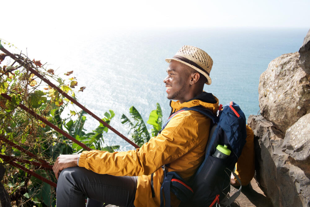 happy-young-african-american-male-traveler-relaxing-outdoors